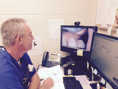 Dentist, Dr. Frank Gupton in photo above treats patients remotely using the technology of telehealth.